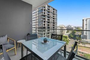 d'une table et de chaises sur un balcon avec vue sur un bâtiment. dans l'établissement Cozy 2 bed Retreat Milton - Pool, Walk to SStadium, à Brisbane