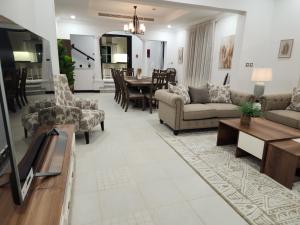 a living room with couches and a dining room at Whispering Pines Jumeirah Golf Estates by Golden Casa in Dubai