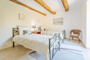 1 Schlafzimmer mit 2 Betten und einem Stuhl in der Unterkunft Chambre d'hôte La Chapelle in La Rochelle-Normande