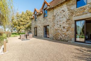 un edificio de piedra con un patio exterior. en Chambre d'hôte La Chapelle, en La Rochelle-Normande