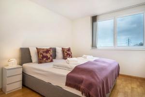 a bedroom with a large bed with a window at Cocoon am Schloß Top 2 in Lochau