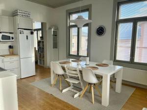 a white kitchen with a white table and chairs at 19th century house with parking hall, own entrance and terrace in Vaasa