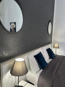 una camera da letto con un grande specchio e un letto con cuscini blu di Amarillo a Palermo
