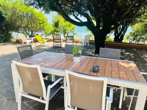 una mesa de madera con sillas y una mesa con una planta. en Villa GREG stupenda location sulla spiaggia con accesso diretto al mare en Terracina