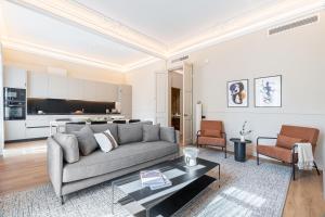 uma sala de estar com um sofá e uma mesa em Aspasios Rambla Catalunya Suites em Barcelona