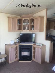 a living room with a tv and a fireplace at J.R. Holiday Homes in Clacton-on-Sea