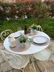 a white table with plates and wine bottles on it at L'Atelier d'Olga - Homillesime in Dijon