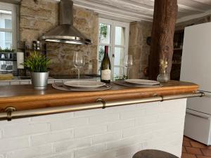 a kitchen with a counter with two glasses of wine at L'Atelier d'Olga - Homillesime in Dijon