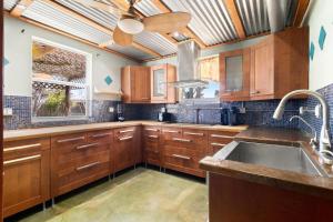 a kitchen with wooden cabinets and a sink and a window at Relaxing Bungalow Walkable to the Beach! in St Pete Beach