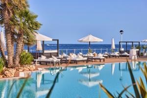 basen z krzesłami i oceanem w tle w obiekcie AluaSoul Menorca - Adults Only w mieście S'Algar +24 zdjęcia