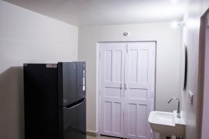 a kitchen with a black refrigerator and a sink at Gooseberry Garden in Ayodhya