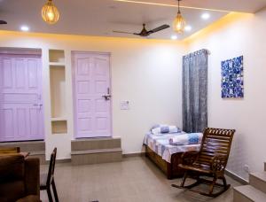 een slaapkamer met een bed en een stoel erin bij Gooseberry Garden in Ayodhya