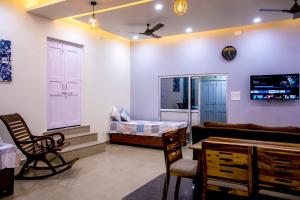 - un salon avec un canapé et un lit dans l'établissement Gooseberry Garden, à Ayodhya