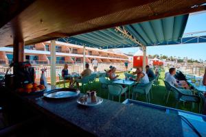 a group of people sitting at tables in a restaurant at Balcon del Mar in Puerto Rico de Gran Canaria