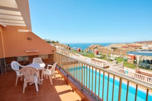 een balkon met een tafel en stoelen en uitzicht op de oceaan bij Balcon del Mar in Puerto Rico de Gran Canaria