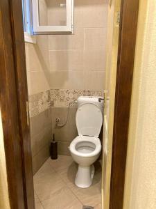 een badkamer met een toilet in een kleine kamer bij Summer Host House in Sozopol