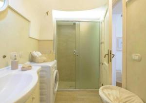 ein Bad mit einer Dusche und einer Waschmaschine in der Unterkunft Trullo U Selvese in Alberobello