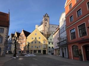 a city street with colorful buildings and a clock tower at Hotel Füssen in Füssen