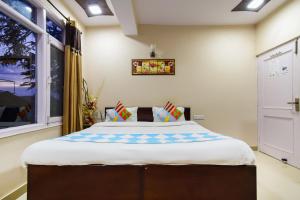 a large bed in a room with a window at OYO Home Sam Villa Studio in Shimla