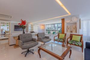 uma sala de estar com uma mesa de vidro e cadeiras em Condomínio Mykonos #400 - Apê Deluxe em Fortaleza por Carpediem em Fortaleza