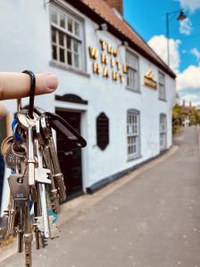 una persona che tiene un mazzo di chiavi di fronte a un edificio di The White Hart a Brigg