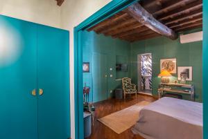 ein Schlafzimmer mit blauen Wänden und einem Bett und einem Schreibtisch in der Unterkunft Ripense in Rom