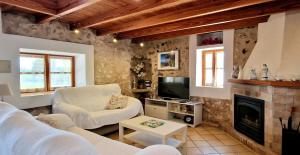 a living room with white furniture and a fireplace at Increible finca rustica con piscina in Selva