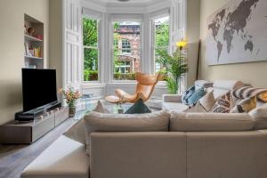 a living room with a couch and a large window at Stylish Elegance in City's Heart in Edinburgh