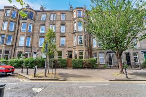 a large brick building with a car parked in front of it at Stylish Elegance in City's Heart in Edinburgh