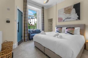 a bedroom with a large white bed and a window at Stylish Elegance in City's Heart in Edinburgh