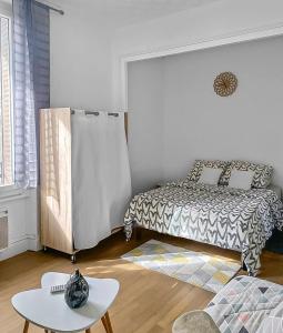sypialnia z łóżkiem i stołem w obiekcie Balade à Montluçon w mieście Montluçon