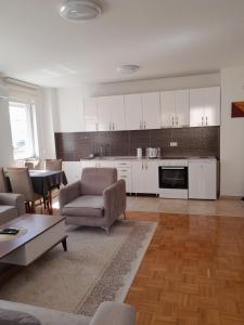 a living room with white cabinets and a table and chairs at Gray Apartment 1 Pristina in Prishtinë