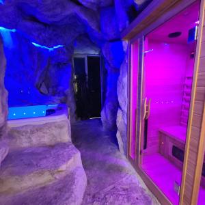 um quarto com uma gruta de pedra com luzes rosa e azul em Napoli Centro Suite e Spa em Nápoles