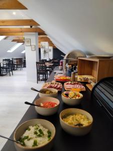un buffet con tazones de comida en una mesa en Hotel Nenufar Premium, en Kościan