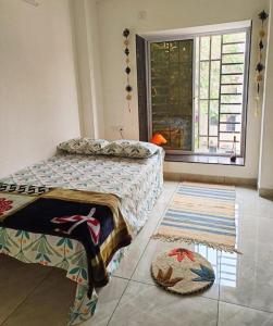 1 dormitorio con cama, ventana y alfombra en Traveller's Nest By My Fav Nest en Siliguri
