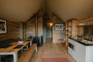 a kitchen with a table and a stove in a room at Llechwedd Glamping in Blaenau-Ffestiniog