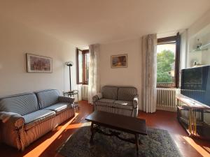 ein Wohnzimmer mit einem Sofa und einem TV in der Unterkunft Casa Preziosa - Salò in Salò