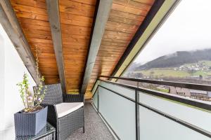 een balkon met 2 stoelen en een groot raam bij Ferienwohnung Sonnenschein in Baiersbronn