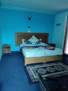 1 dormitorio con 1 cama con pared azul en Dream villa, en Leh