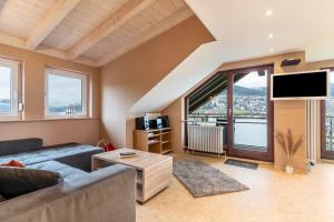 un soggiorno con un divano e una grande finestra di Fewo Sonnenschein - Haus Sommerberg a Baiersbronn