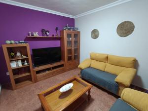 a living room with a couch and a table at Rincón de Joel Habitación con baño privado in La Orotava