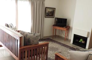 a living room with a crib and a fireplace at Blue Mountain Bay in Simonʼs Town