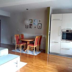 eine Küche mit einem Tisch und Stühlen sowie einem Kühlschrank in der Unterkunft Apartman Lončar in Posušje