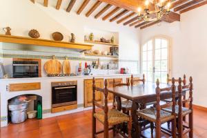uma cozinha com uma mesa e cadeiras e uma lareira em Podere Fonte del Merlo em Fauglia