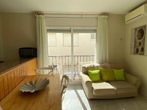 a living room with a couch and a table at INNOUTHOME APARTAMENTO CON WIFI y AA_BALMES I in L'Ametlla de Mar
