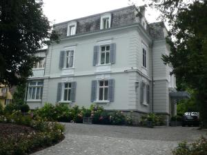 a white house with flowers in front of it at Entire Zurich Villa, Your Private Luxury Escape in Zürich