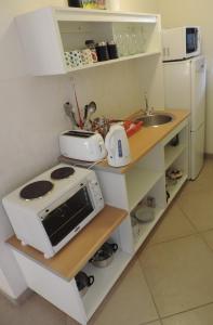 a kitchen with a counter with a microwave and a sink at Blue Mountain Bay in Simonʼs Town