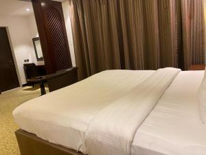 ein großes weißes Bett in einem Hotelzimmer in der Unterkunft Ista Suites Seef in Manama