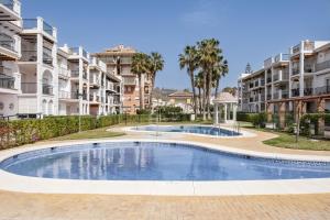a swimming pool in front of some apartment buildings at Experiencia Marina A107 in Torrox