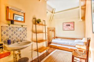 uma casa de banho com um lavatório e uma cama num quarto em La Rabouillère - House in Omaha Beach em Commes